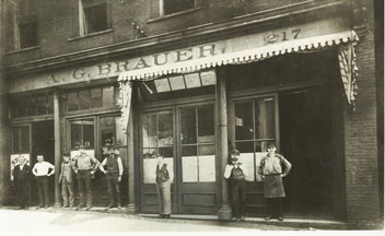 The Brauer staff is here shown in 1884 in front of the Company's second location. A.G. Brauer is the third man from the right.